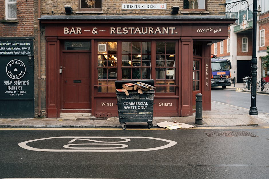 The image shows the front exterior of a closed pub or restaurant on a city street, featuring a brown wooden facade with large glass windows and a matching brown door. Above the entrance, a sign reads